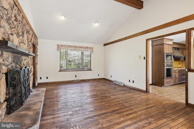 unfurnished living room with high vaulted ceiling, a stone fireplace, beamed ceiling, visible vents, and hardwood / wood-style flooring