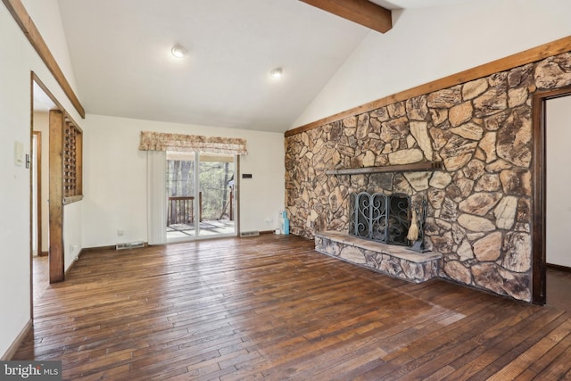 unfurnished living room with visible vents, a stone fireplace, beam ceiling, and hardwood / wood-style flooring