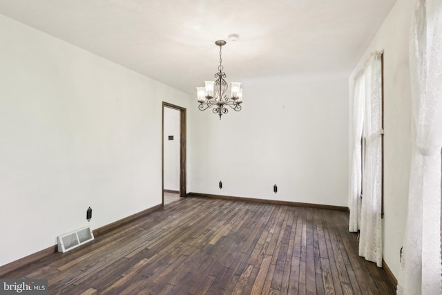 unfurnished dining area featuring baseboards, dark wood-style flooring, a chandelier, and visible vents