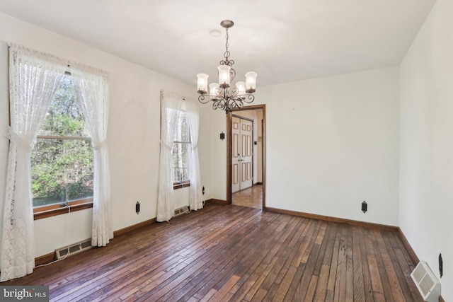 unfurnished dining area with a chandelier, visible vents, a wealth of natural light, and hardwood / wood-style floors
