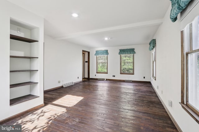 unfurnished living room with hardwood / wood-style flooring, beam ceiling, and visible vents
