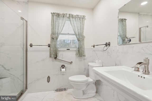 bathroom featuring tile walls, visible vents, a marble finish shower, and a sink