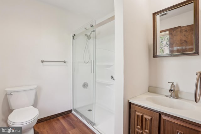 full bath with vanity, a shower stall, toilet, and wood finished floors