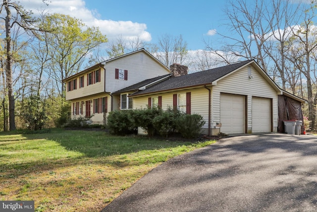 view of front of home featuring driveway, a chimney, roof with shingles, a front lawn, and an attached garage