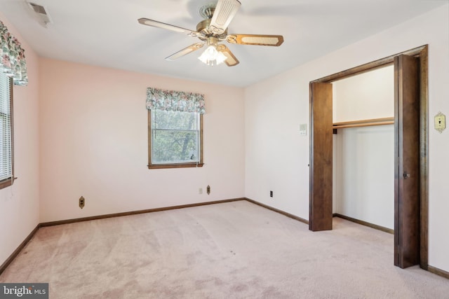 unfurnished bedroom featuring light colored carpet, a ceiling fan, baseboards, and a closet