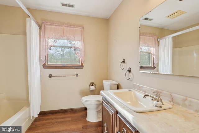 bathroom with toilet, wood finished floors, and visible vents
