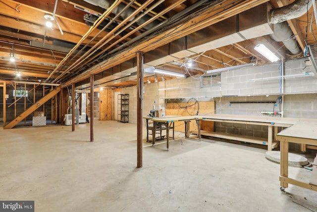 unfinished basement with heating unit and a workshop area