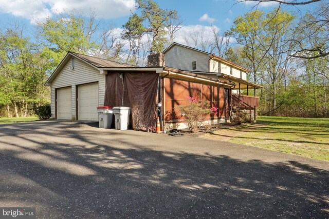 view of side of property featuring a sunroom and a detached garage