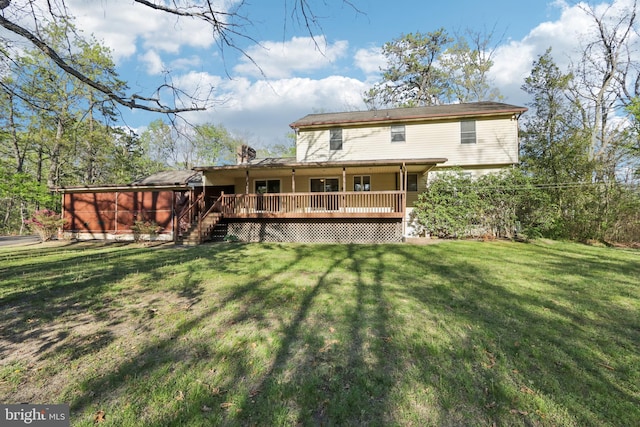 rear view of property with a yard and a deck