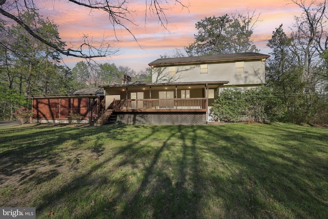 rear view of property with a lawn, a wooden deck, and stairway
