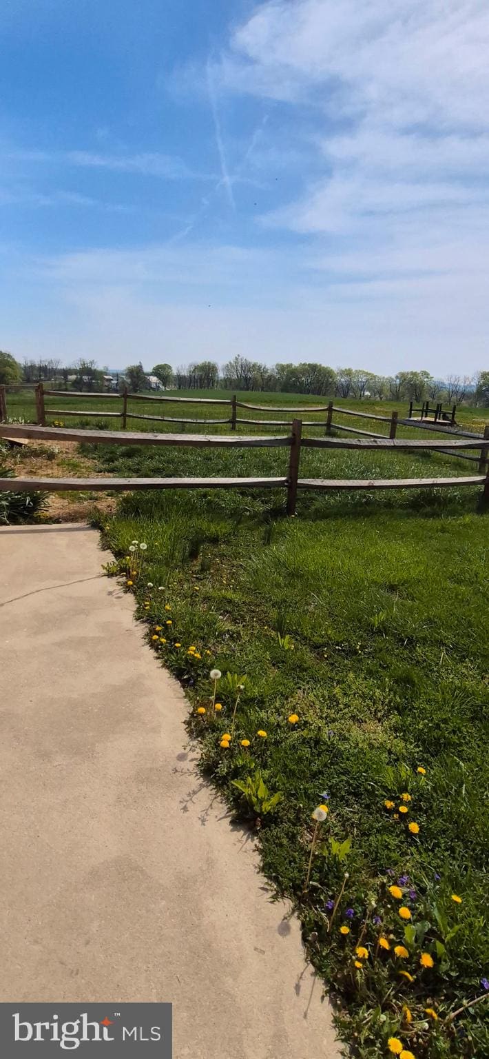 view of yard featuring fence and a rural view