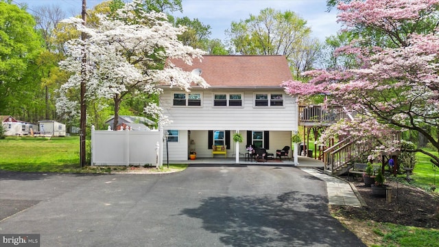 colonial inspired home featuring stairs, fence, and driveway