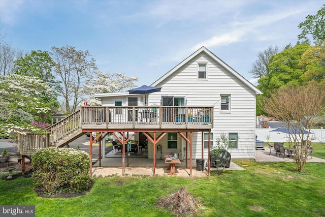 rear view of property featuring a lawn, a patio area, a wooden deck, and stairway