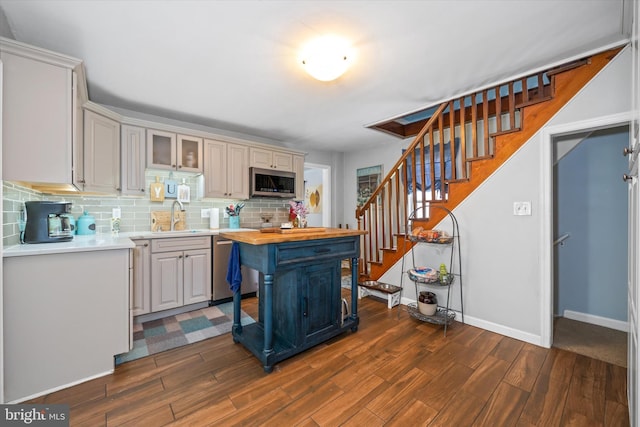kitchen with dark wood-style floors, appliances with stainless steel finishes, butcher block counters, and a sink