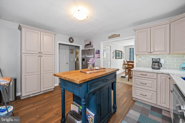 kitchen featuring appliances with stainless steel finishes, wooden counters, baseboards, tasteful backsplash, and dark wood-style floors