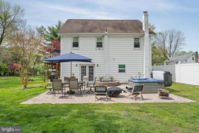 rear view of property with a fire pit, fence, a patio, a chimney, and a lawn