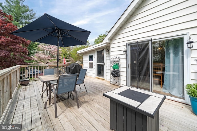 deck featuring outdoor dining area and a grill