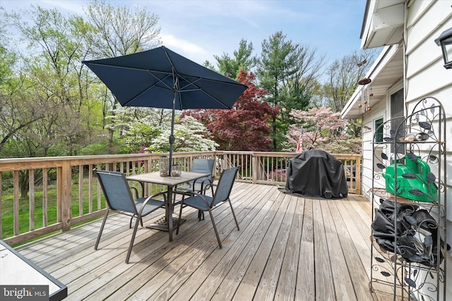 wooden terrace featuring outdoor dining area and area for grilling