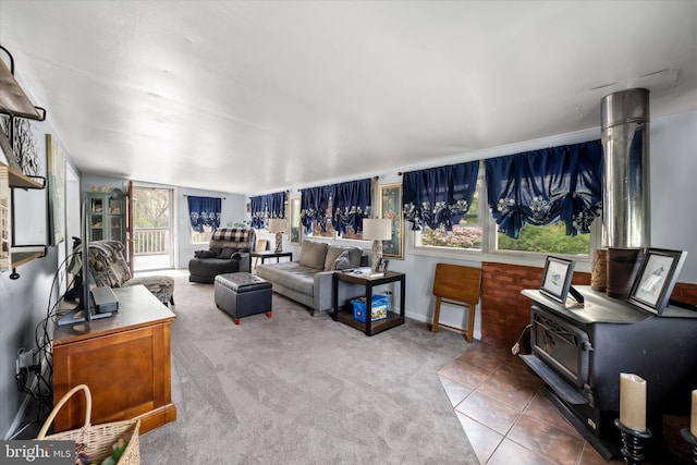 carpeted living room featuring tile patterned flooring, a wood stove, and baseboards