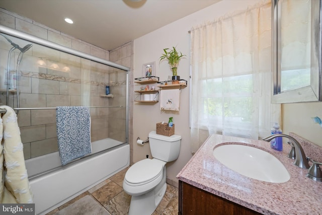 bathroom with toilet, combined bath / shower with glass door, and vanity