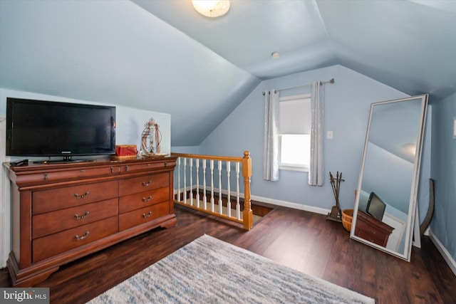 bedroom with baseboards, lofted ceiling, and dark wood-type flooring