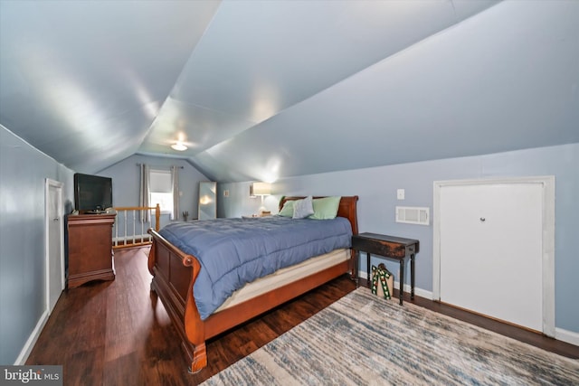 bedroom with baseboards, vaulted ceiling, wood finished floors, and visible vents