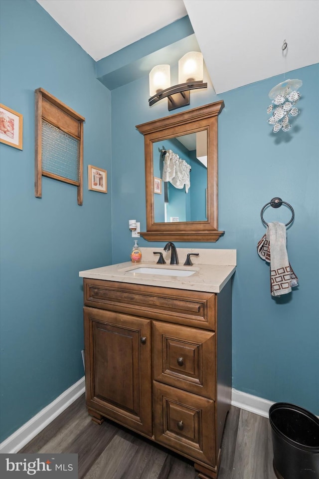 bathroom with vanity, baseboards, and wood finished floors