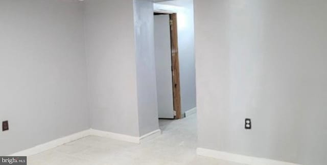 unfurnished room with baseboards