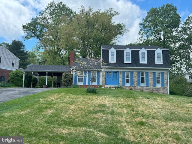 front of property featuring a front yard, driveway, a chimney, and a carport