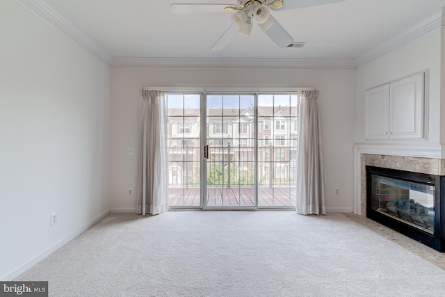 unfurnished living room with carpet floors, crown molding, visible vents, a fireplace, and ceiling fan
