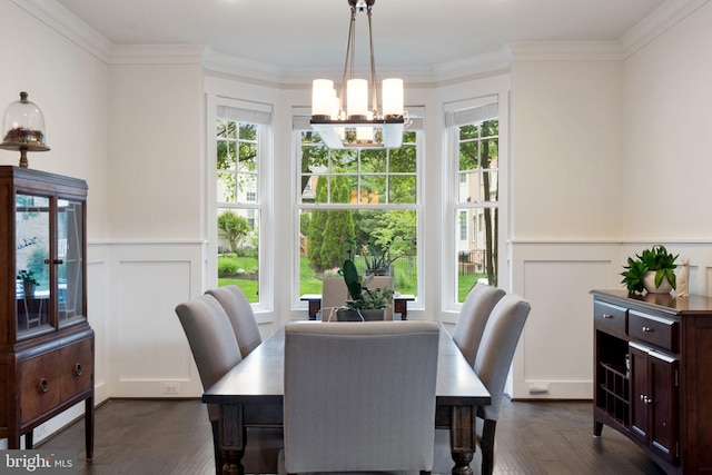 dining room featuring dark wood-style floors, a chandelier, a decorative wall, ornamental molding, and a wainscoted wall