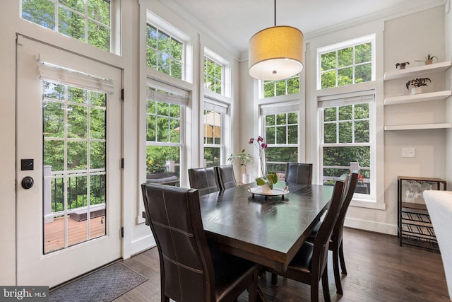 dining room featuring ornamental molding, dark wood-style flooring, a high ceiling, and baseboards