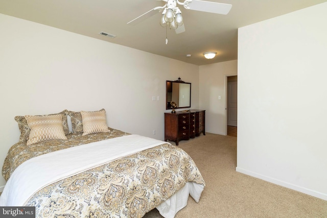 bedroom featuring baseboards, light carpet, a ceiling fan, and visible vents
