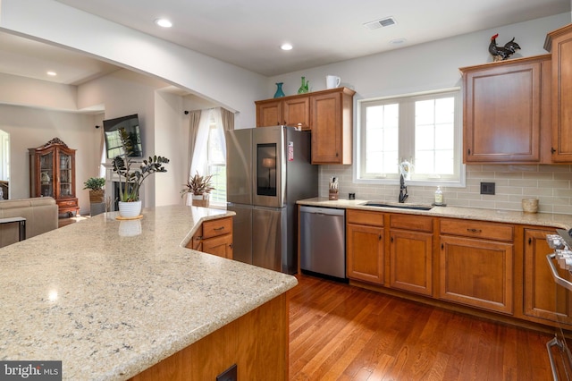 kitchen with visible vents, brown cabinets, a sink, dark wood-style floors, and stainless steel appliances