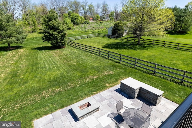 view of yard with a patio, a rural view, and fence