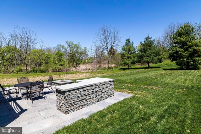 view of yard featuring a patio, an outdoor fire pit, and outdoor dining space
