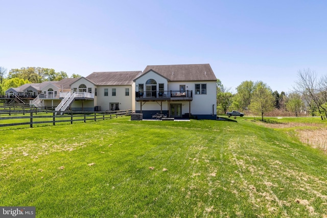 back of property with a lawn, fence, and a wooden deck