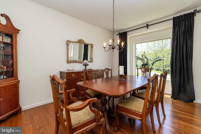 dining area with an inviting chandelier, baseboards, and wood finished floors