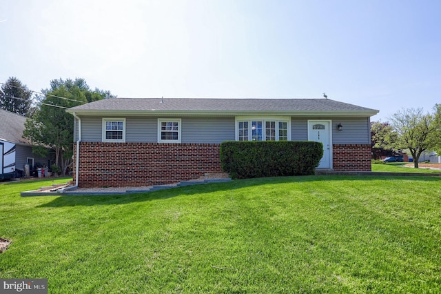 ranch-style house featuring brick siding and a front yard