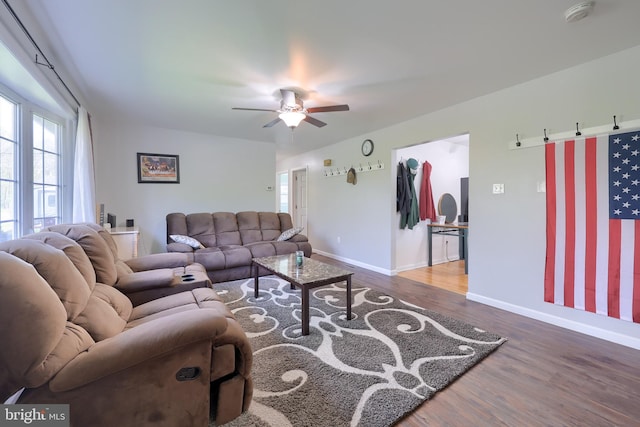 living room featuring a ceiling fan, baseboards, plenty of natural light, and wood finished floors