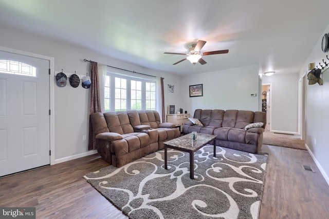 living area with visible vents, baseboards, ceiling fan, and wood finished floors