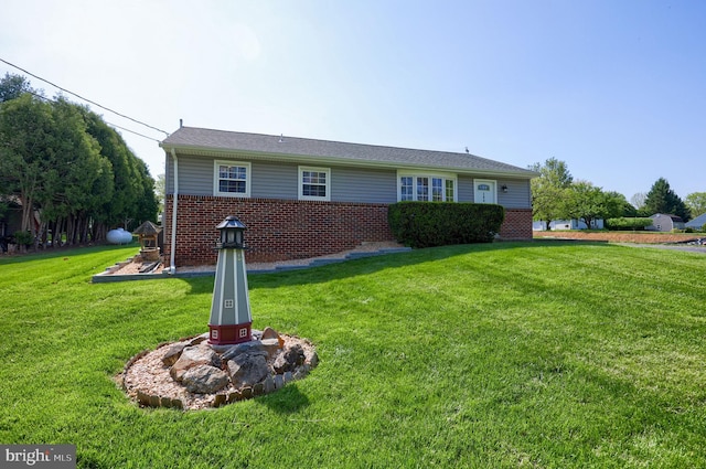 view of front of home featuring a front yard and brick siding