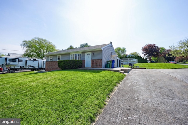 ranch-style house featuring brick siding and a front lawn