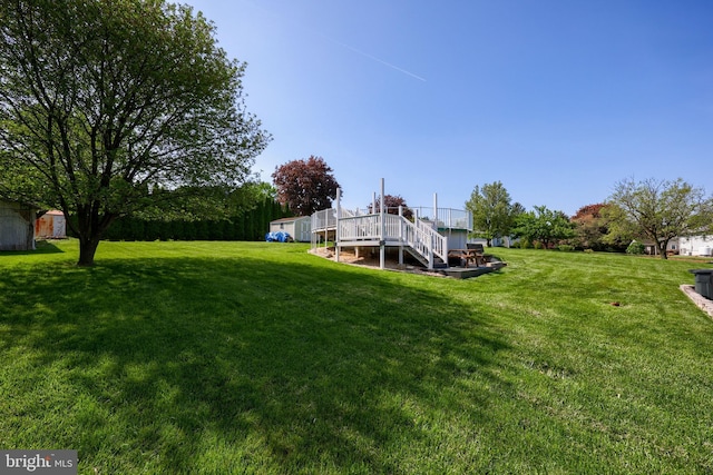 view of yard featuring a deck and stairs