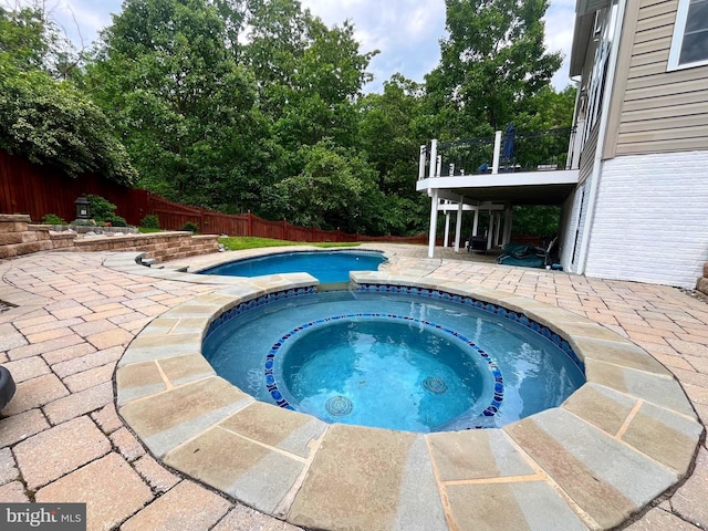 view of swimming pool featuring a patio area, a fenced backyard, and a pool with connected hot tub
