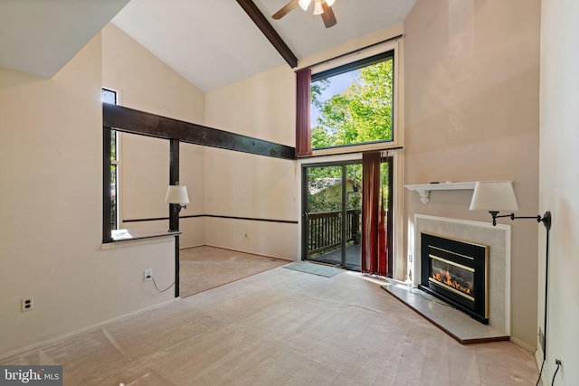 entryway featuring ceiling fan, a high end fireplace, beam ceiling, high vaulted ceiling, and carpet