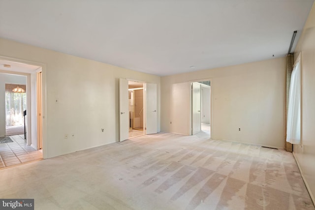 interior space with light colored carpet, a notable chandelier, and visible vents