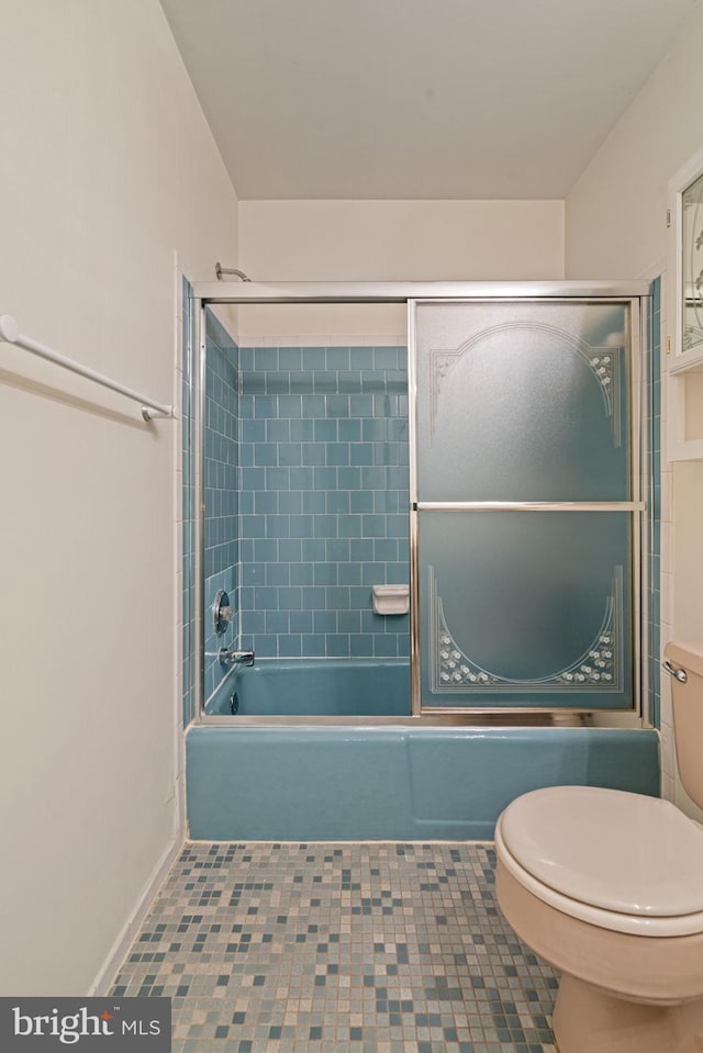 bathroom featuring tile patterned flooring, enclosed tub / shower combo, and toilet
