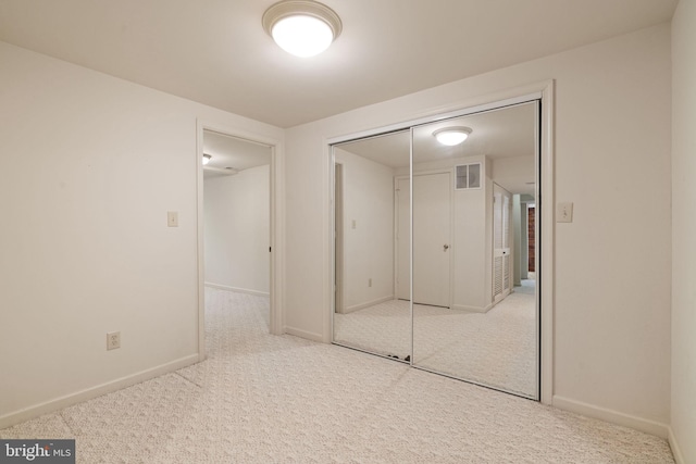 unfurnished bedroom with baseboards, visible vents, carpet, and a closet