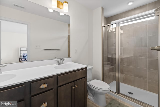 full bath with visible vents, a sink, double vanity, and a shower stall